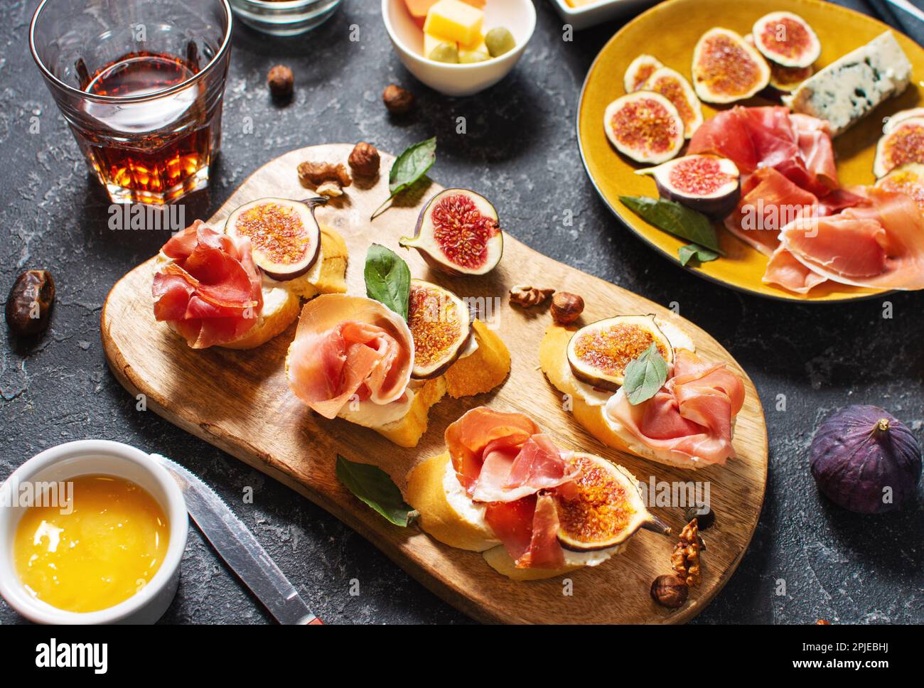 Vorspeisen mit traditionellen spanischen Tapas. Italienische Antipasti Bruschetta mit Prosciutto, Frischkäse und Feige Stockfoto