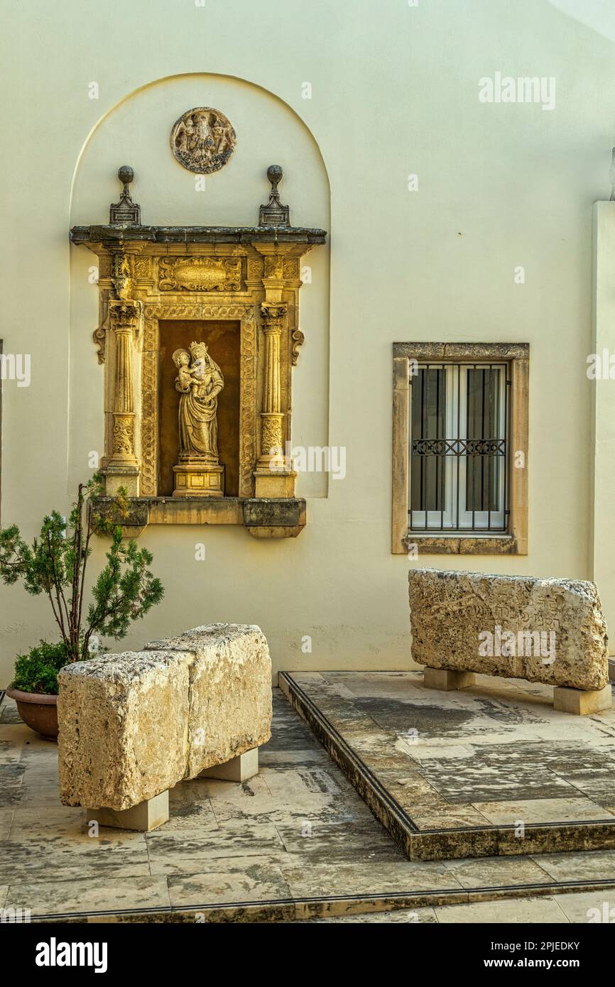 Altar mit Statue der Madonna und des Kindes und den drei jüdischen Grabsteinen im Innenhof der Regionalgalerie Palazzo Bellomo in Syrakus Stockfoto