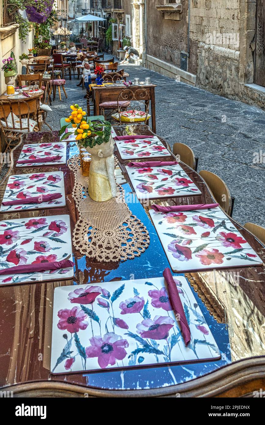 Tische in einem kleinen Restaurant entlang der engen Gassen der Altstadt  von Syrakus, Ortigia. Keramik schmückt den Tisch und schmückt ihn. Sizilien  Stockfotografie - Alamy