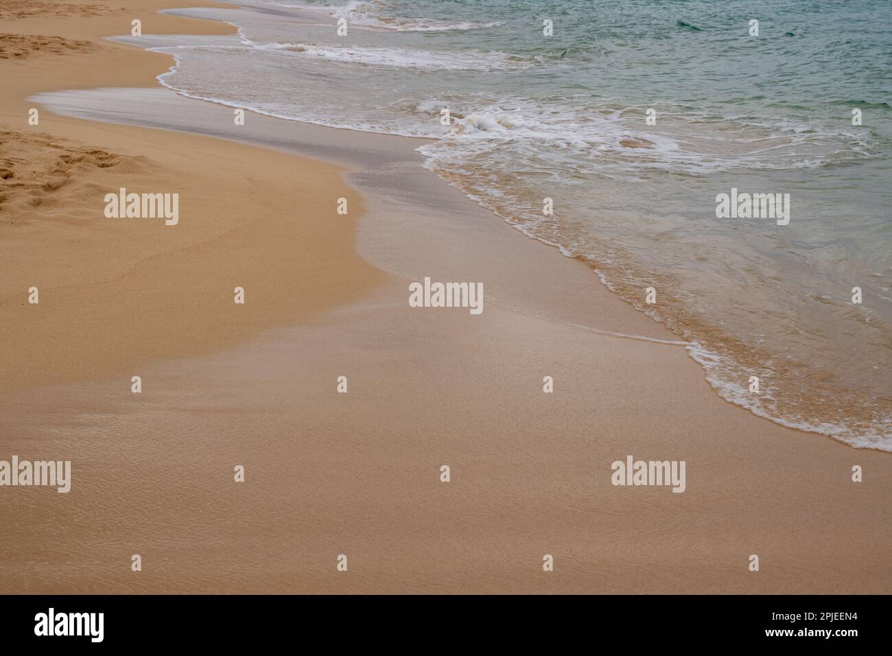 Goldener Sand am Strand, mit einem sanften Hauch von ruhigen Wellen des Atlantischen Ozeans. Parque Natural Dunas de Corralejo, Fuerteventura, Spanien. Stockfoto