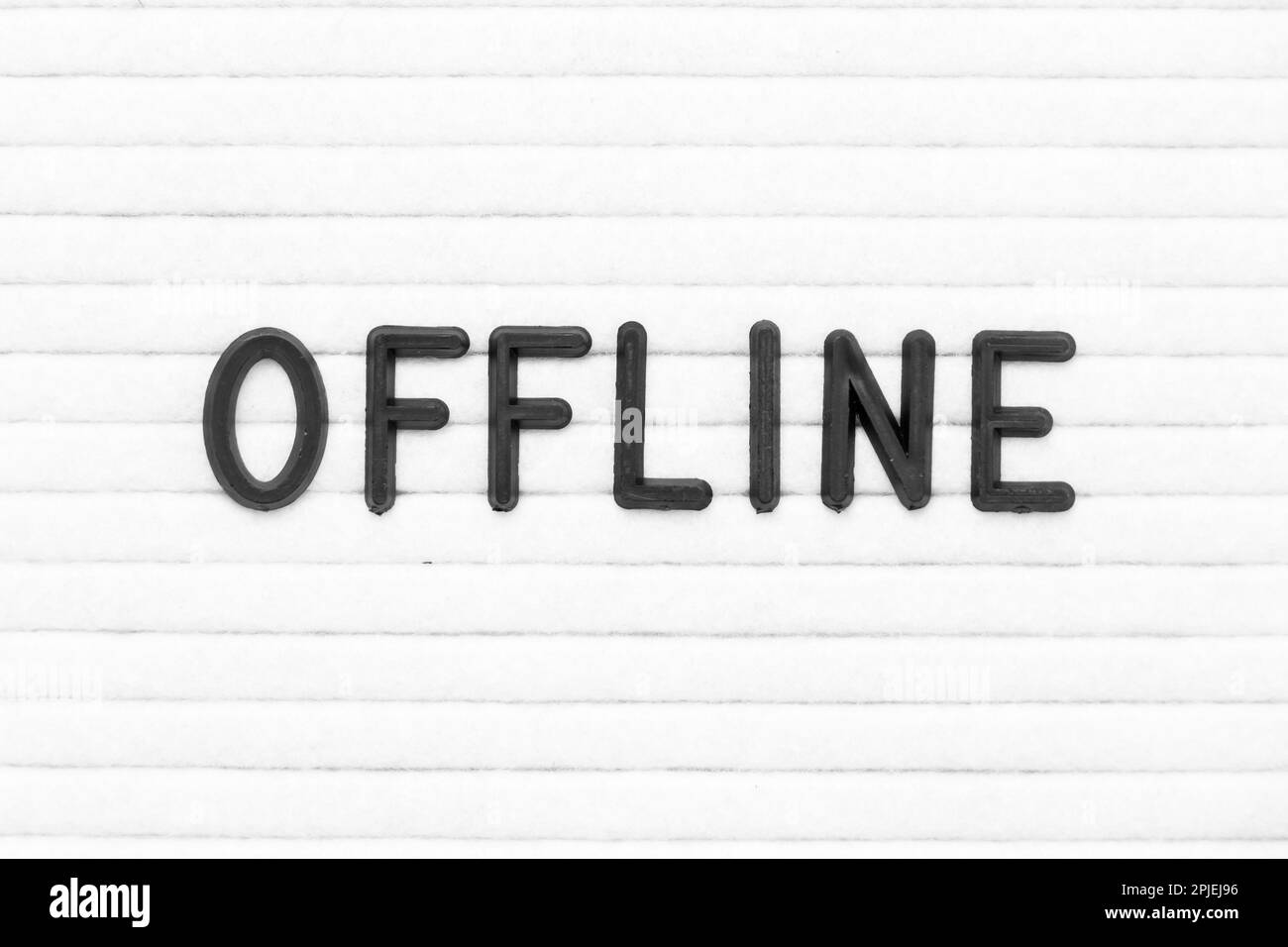 Schwarzer Buchstabe in Word offline auf weißem Filzbretthintergrund Stockfoto