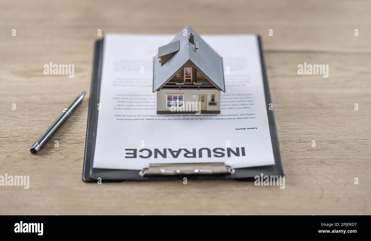 Hausversicherungsvertragskonzept mit einem Hausmodell auf dem Papierkram auf einem Tisch neben einem Stift. Stockfoto Hausversicherungsvertragskonzept mit einem Hausmodell auf dem Papierkram auf einem Tisch neben einem Stift. Stockfoto