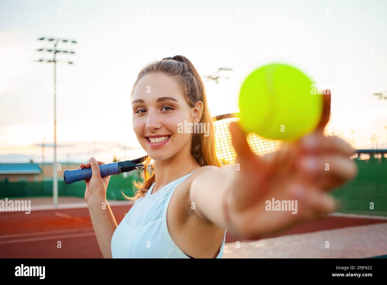 Eine schöne junge Frau spielt Tennis. Sportschläger, das Mädchen lächelt, glücklich. Aktiver Lifestyle, Outdoor-Erholung. Fitness-Körper, Gewichtsverlust, Ruhe-tra Stockfoto