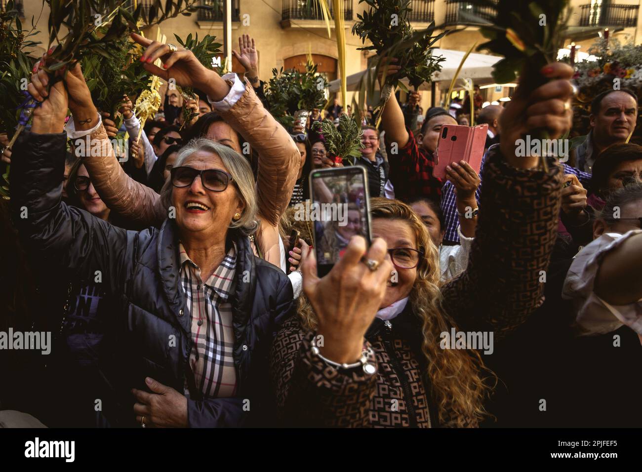 Barcelona, Spanien. 2. April 2023. Die Gläubigen winken mit der Planke, während der Priester sie am Ende der Palmensonntagsprozession in Barcelona segnet. Credit: Matthias Oesterle/Alamy Live News Stockfoto