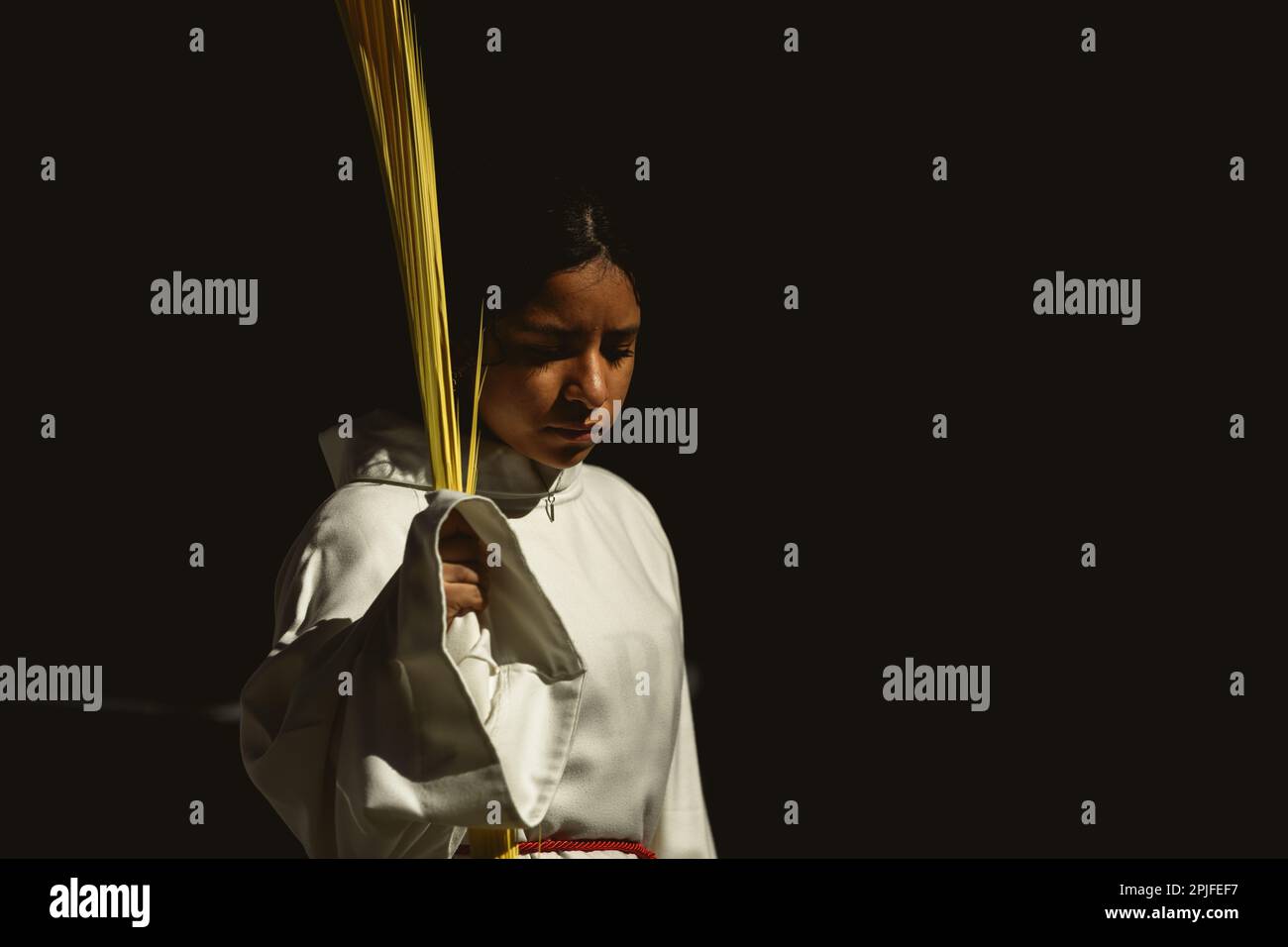 Barcelona, Spanien. 2. April 2023. Ein junger Bußgesicht der Brüderschaft „Gran Poder und Macarena Esperanza“ läuft auf der Straße mit einem Palmenzweig während der Palmensonntagsprozession in Barcelona. Kredit: Matthias Oesterle/Alamy Live News Stockfoto