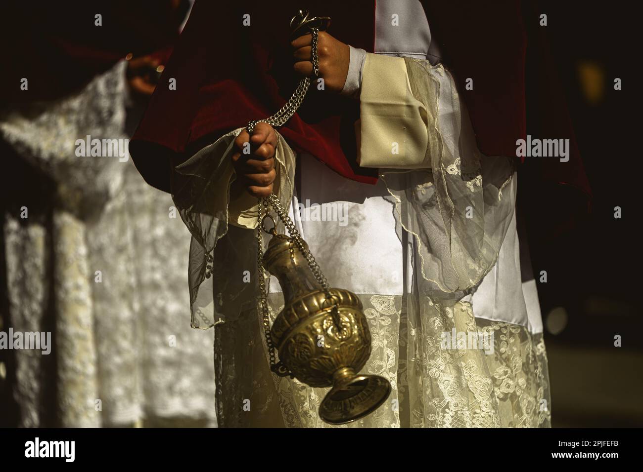 Barcelona, Spanien. 2. April 2023. Ein Gefolgsmann aus der Bruderschaft 'Gran Poder und Macarena Esperanza' wandelt während der Palm Sunday Prozession in Barcelona auf der Straße mit Weihrauch. Kredit: Matthias Oesterle/Alamy Live News Stockfoto