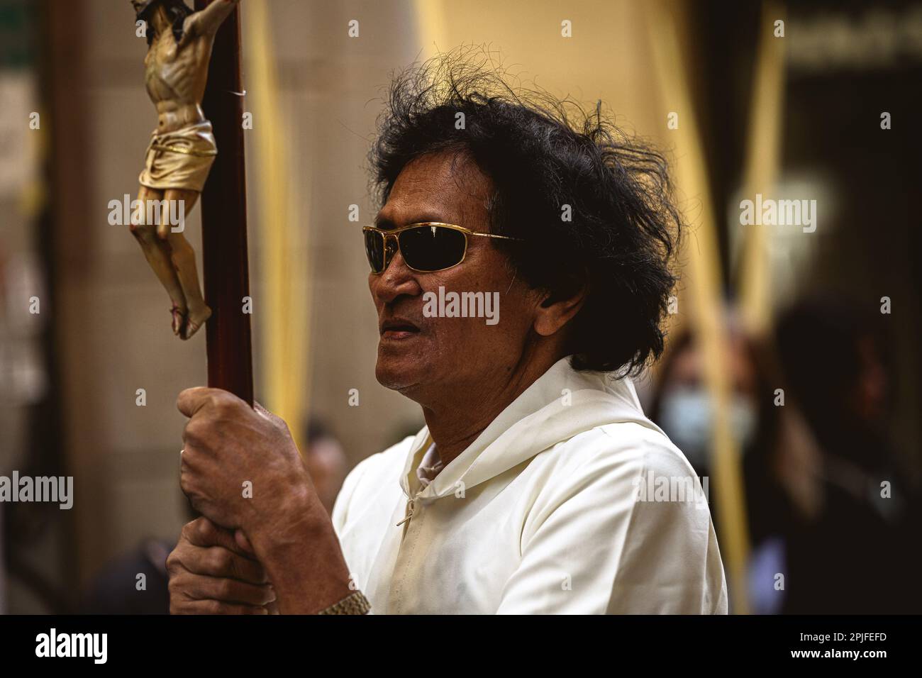 Barcelona, Spanien. 2. April 2023. Ein Bußgesuch der Brüderschaft „Gran Poder und Macarena Esperanza“ läuft auf der Straße mit einem Palmenzweig während der Palmensonntagsprozession in Barcelona. Kredit: Matthias Oesterle/Alamy Live News Stockfoto