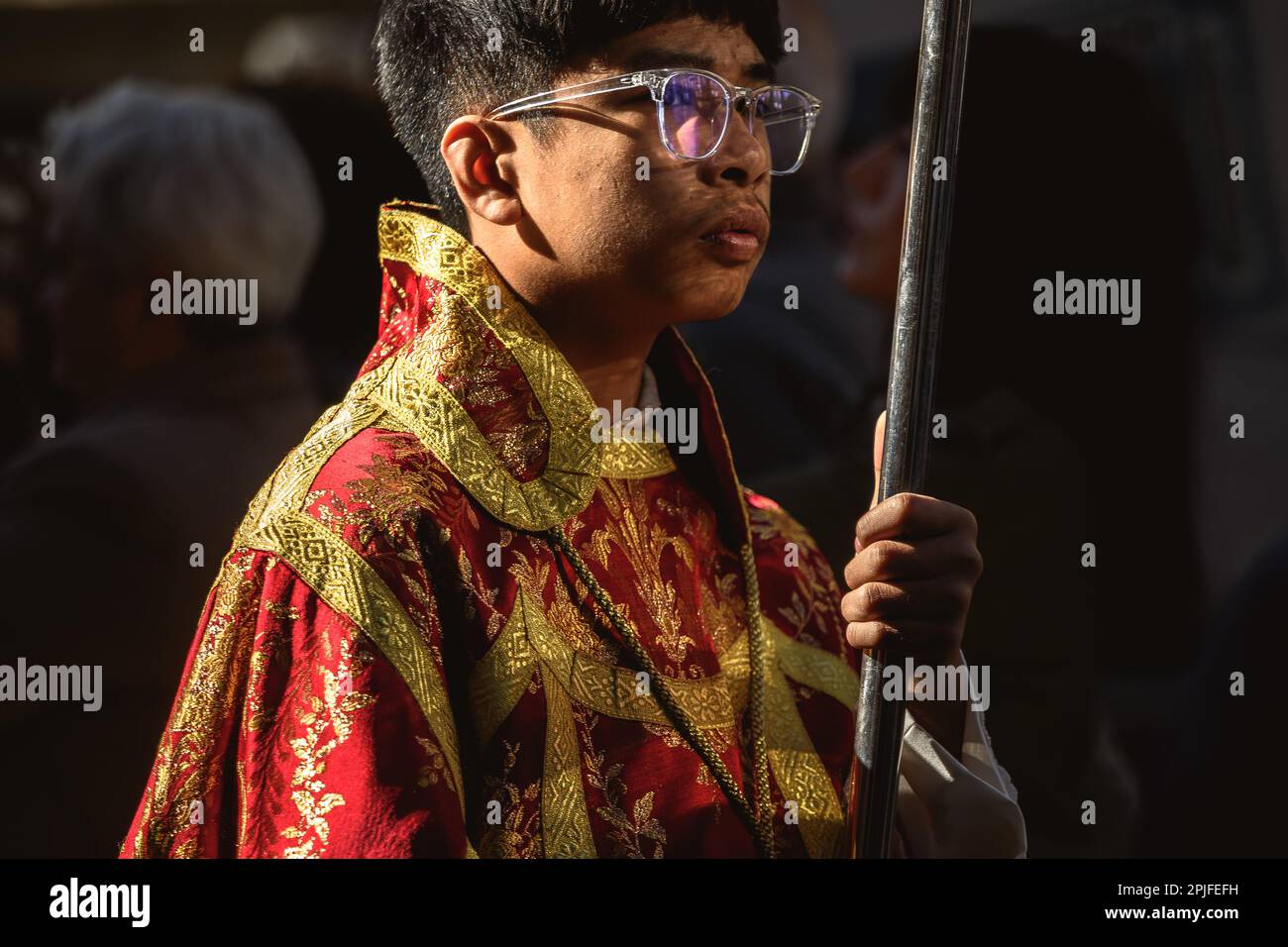 Barcelona, Spanien. 2. April 2023. Ein junger Bußgesicht der Brüderschaft „Gran Poder und Macarena Esperanza“ läuft auf der Straße mit einem Palmenzweig während der Palmensonntagsprozession in Barcelona. Kredit: Matthias Oesterle/Alamy Live News Stockfoto