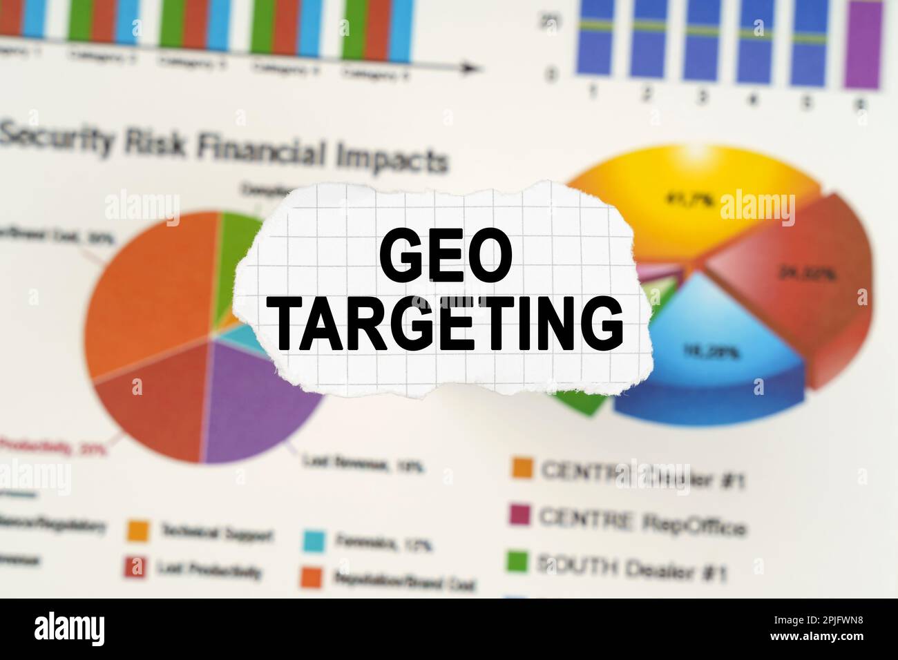Geschäftskonzept. Auf Diagrammen und Diagrammen liegt zerrissenes Papier mit der Aufschrift „GEO TARGETING“. Diagramme und Diagramme sind verschwommen. Stockfoto