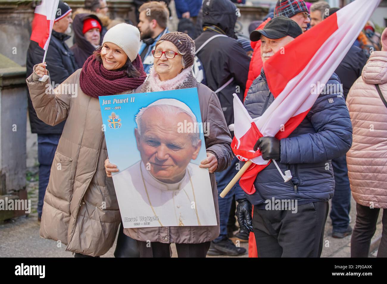 Danzig, Polen, April 2. 2023 mehrere hundert Menschen mit Porträts von Johannes Paul II. Und Flaggen des Vatikans gingen in das sogenannte. Papstmarsch zur Verteidigung von Papst Johannes Paul II. Am 2. April 2023 in Danzig, Polen. Die Teilnehmer des marsches sind hauptsächlich Rentner und ältere Menschen, inspiriert von katholischen Priestern und Politikern der herrschenden rechtsgerichteten Koalition. Der marsch wurde nach einem hochrangigen TVN-Bericht organisiert, der enthüllte, dass der Papst über Pädophilie in der katholischen Kirche Bescheid wusste und aktiv dazu beitrug, sie zu verbergen, einschließlich der Überstellung von Priestern, die der Pädophilie verdächtigt werden, in andere Gemeinden. Cre Stockfoto