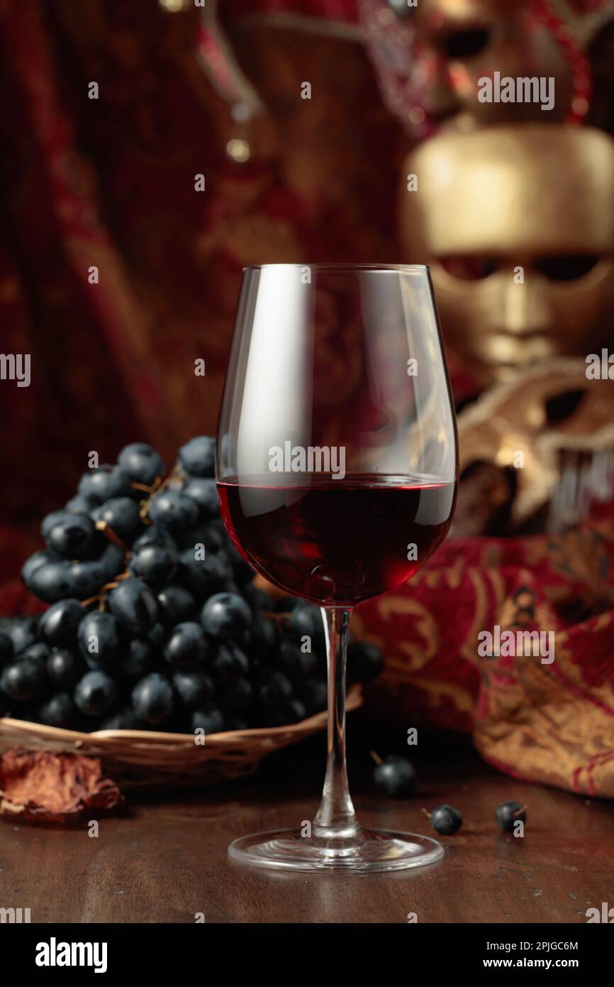 Stillleben mit Rotwein, Trauben und Jahrgangsmasken. Stockfoto
