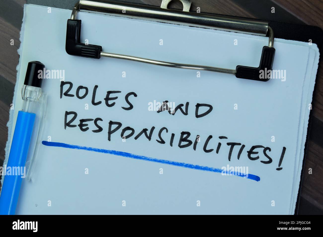 Konzept der Rollen und Verantwortlichkeiten Schreiben Sie auf Unterlagen, die isoliert auf einem Holztisch liegen. Stockfoto