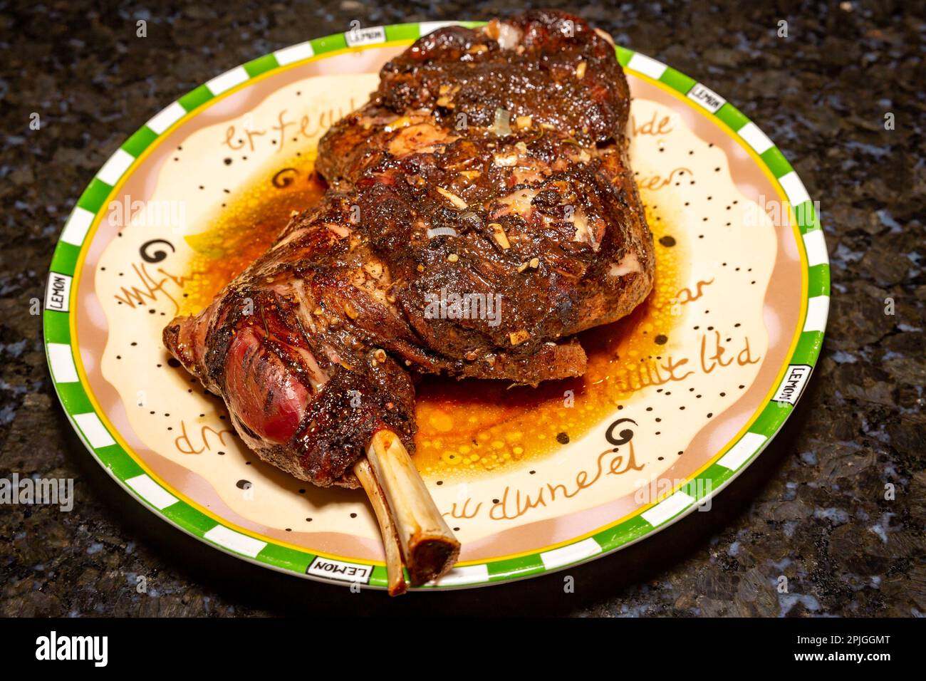 Traditionelles rohes Lammschulterfleisch, das zum Braten mit syrischen Gewürzen, Knoblauch, Thymian und Rosmarin zubereitet wird. Dunkler Hintergrund. Stockfoto