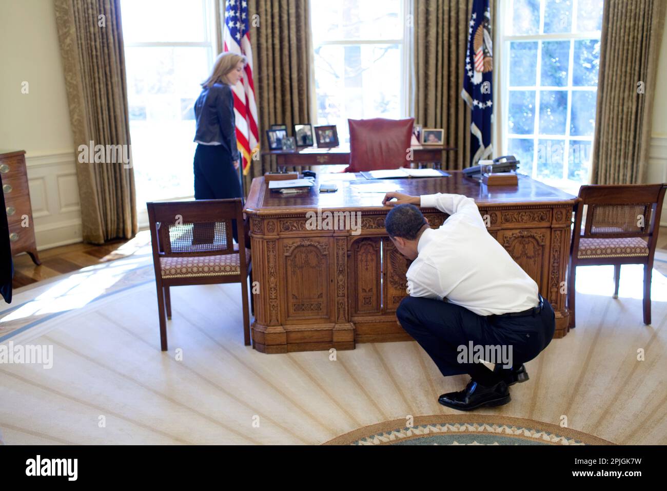 Präsident Barack Obama untersucht die Resolute Desk am 3. März 2009, während des Besuchs mit Caroline Kennedy-Schlossberg im Oval Office. Eine berühmte Fotographie spähte ihr Bruder John, durch die FDR-Panel, während sein Vater Präsident Kennedy arbeitete.  Offiziellen White House Photo by Pete Souza Stockfoto