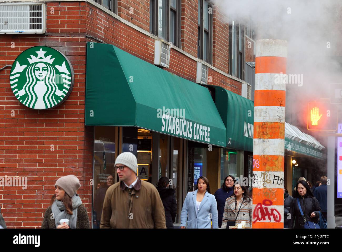 Leute, die an einem Starbucks in der 145 Third Ave, New York, in der Nähe des Stuyvesant Square Park in Manhattan vorbeilaufen. Stockfoto