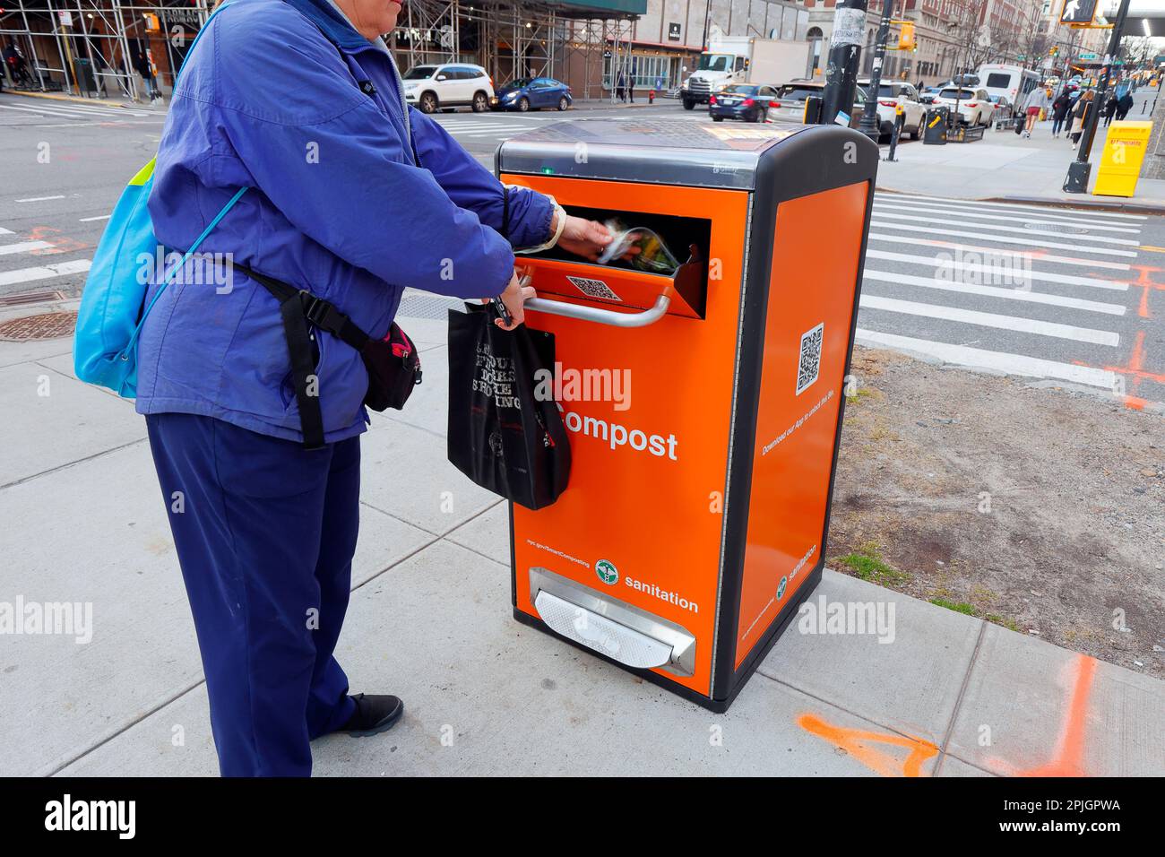 Eine Person lagert Essensreste in einen NYC Smart Kompost-Behälter ab. Die Recyclingbehälter müssen mit der NYC Smart Compost App entriegelt werden Stockfoto