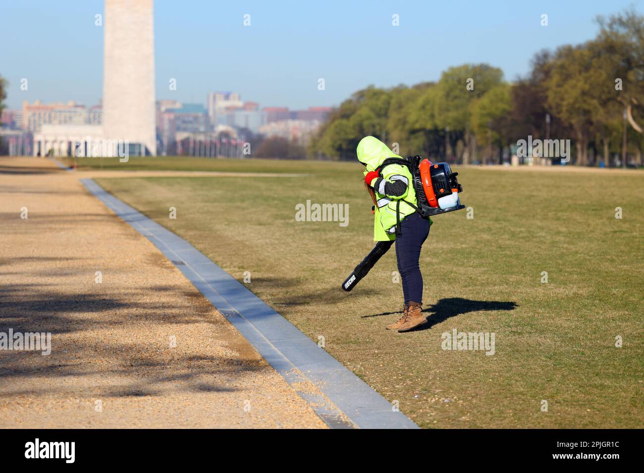 Ein Arbeiter mit einem gasbetriebenen Laubbläser, der Kies und lose Steine vom Rasen der National Mall in Washington DC drückt. Bundeseigentum ist ausgenommen Stockfoto