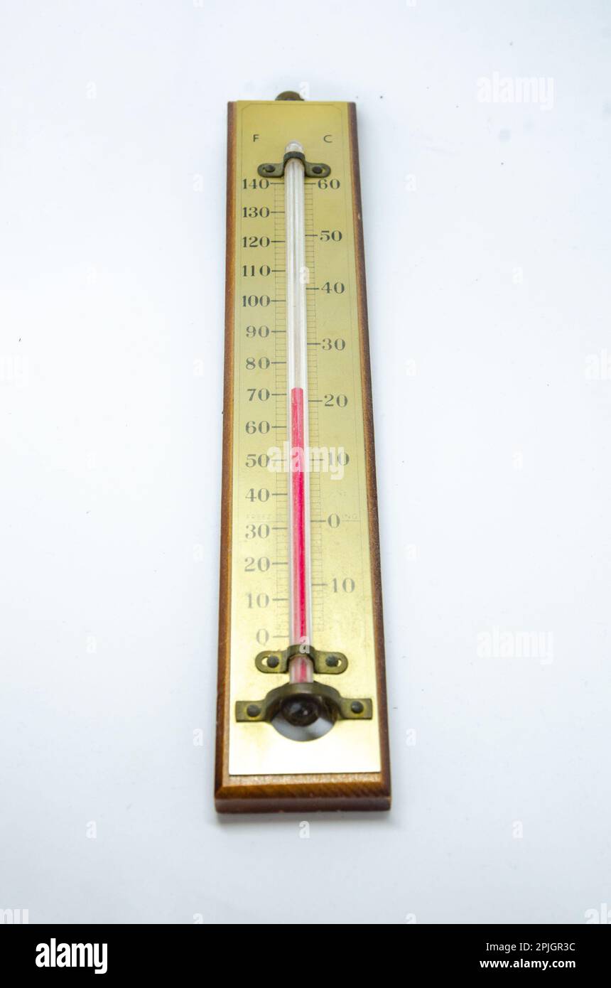 Ein altes Thermometer, das eine Flüssigkeit auf Basis von rotem Spiritus enthält, die zur Temperaturmessung eine Skala nach oben geht. Stockfoto