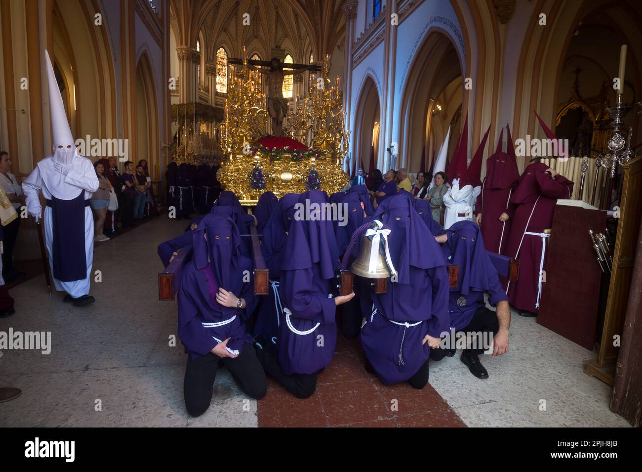 Die Brüder „Salud“ werden in einer Kirche gesehen, wie sie sich vorbereiten, bevor sie während der Feierlichkeiten der Heiligen Woche an der Prozession teilnehmen. Tausende von Menschen feiern die Heilige Woche und warten darauf, die Bruderschaften und Osterprozessionen auf den Straßen der Stadt zu sehen. Die Heilige Woche in Andalusien, die Tausende von Gläubigen und Gläubigen zusammenbringt, gilt als eine der wichtigsten religiösen und kulturellen Feierlichkeiten in der Region. Stockfoto