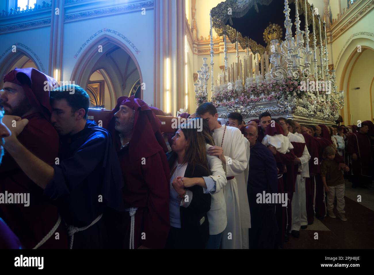 Die Ritter (C) der „Salud“-Bruderschaft werden in einer Kirche emotional gesehen, bevor sie an der Prozession während der Feierlichkeiten der Heiligen Woche teilnehmen. Tausende von Menschen feiern die Heilige Woche und warten darauf, die Bruderschaften und Osterprozessionen auf den Straßen der Stadt zu sehen. Die Heilige Woche in Andalusien, die Tausende von Gläubigen und Gläubigen zusammenbringt, gilt als eine der wichtigsten religiösen und kulturellen Feierlichkeiten in der Region. Stockfoto