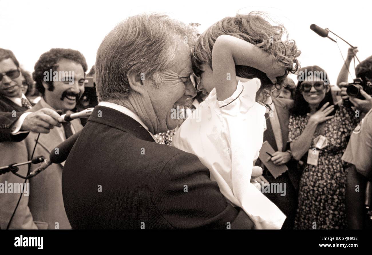 Ein bezauberndes Pressekorps des Weißen Hauses sieht aus, als würde Präsident Carter ein Kind an der Nase reiben. Stockfoto