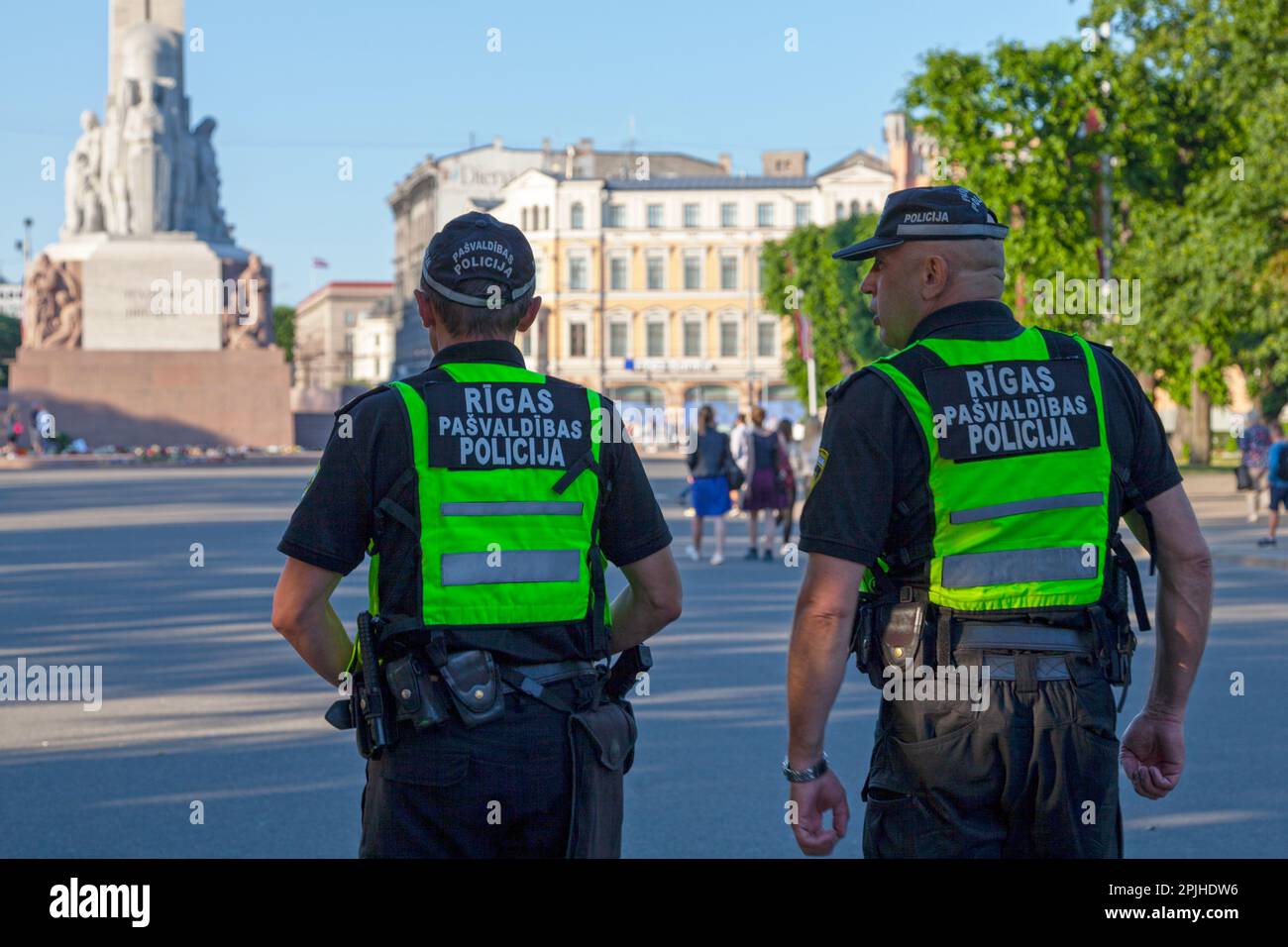 Riga, Lettland - Juni 14 2019: Zwei Beamte der Rigaer Stadtpolizei (Rīgas pašvaldības policija) patrouillieren auf dem Platz in der Nähe des Freiheitsdenkmals. Stockfoto