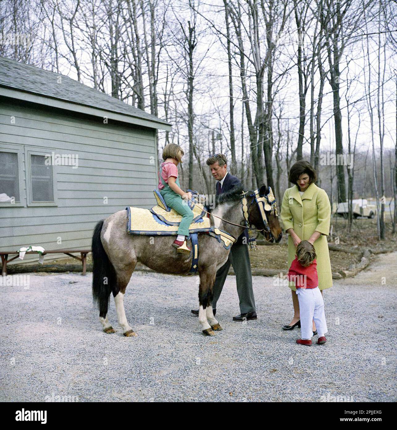 KN-C27671 Wochenende am 31. März 1963 im Camp David. Präsident Kennedy und Mrs. Kennedy mit ihren Kindern Caroline und John Jr. im Camp David in Maryland. Caroline sitzt auf "Macaroni". Der Sattel auf Macaroni war ein Geschenk von König Hassan II. Von Morroco. Bitte schreiben Sie Robert Knudsen. Fotos Vom Weißen Haus. John F. Kennedy Presidential Library and Museum, Boston“ Stockfoto