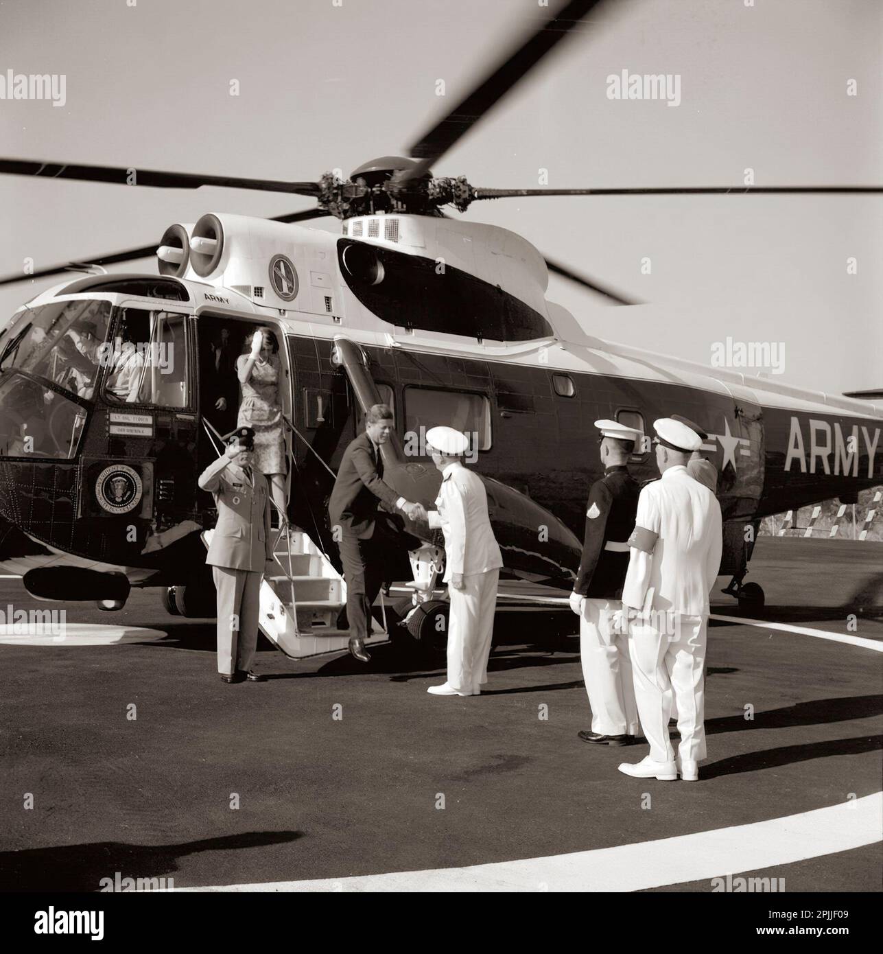 KN-C29277 2. Juli 1963 Präsident John F. Kennedy begrüßt Admiral J.S. Russell, wenn er einen Hubschrauber verlässt. Jean Smith verlässt den Hubschrauber hinter Präsident Kennedy. Nordatlantik-Vertragsorganisation (NATO), Neapel, Italien. Bitte schreiben Sie Robert Knudsen. Fotos Vom Weißen Haus. John F. Kennedy Presidential Library and Museum, Boston“ Stockfoto