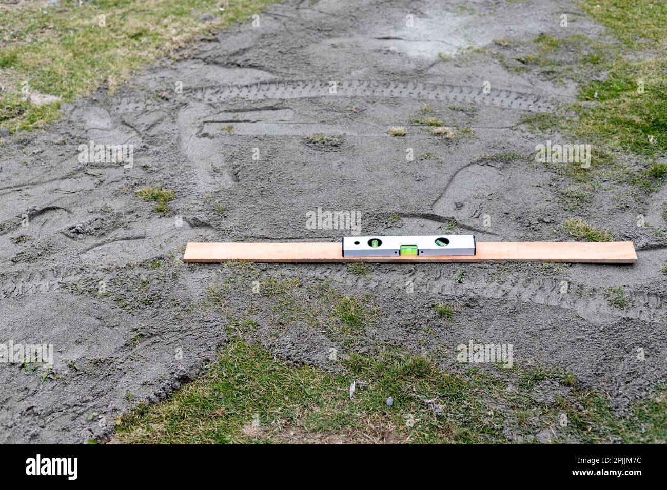 Verwenden Sie eine Wasserwaage zum Bewegen und Planieren von Boden im Rasen Stockfoto