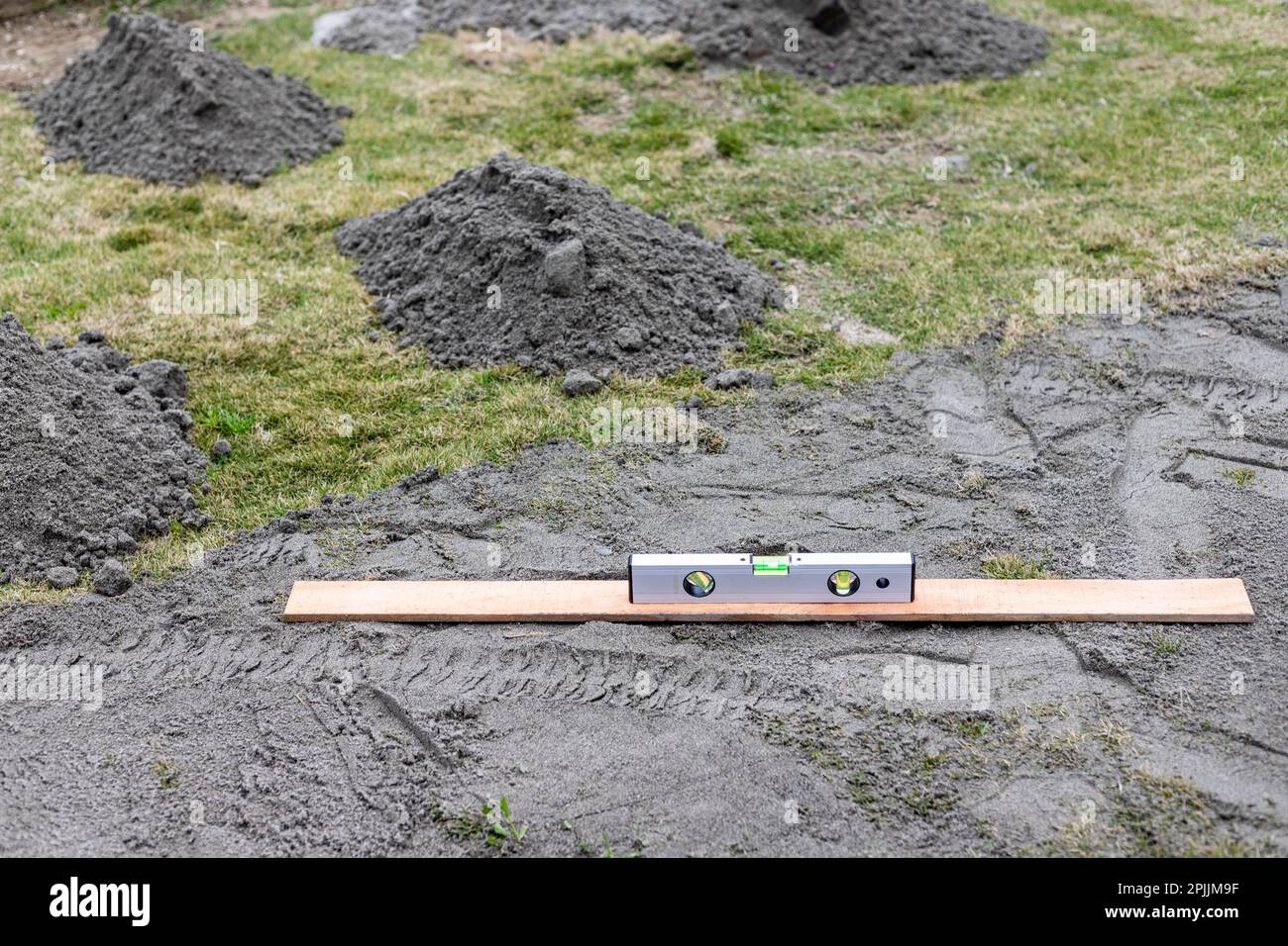 Rasennivellierung und Renovierung mit Hilfe einer Wasserwaage Stockfoto