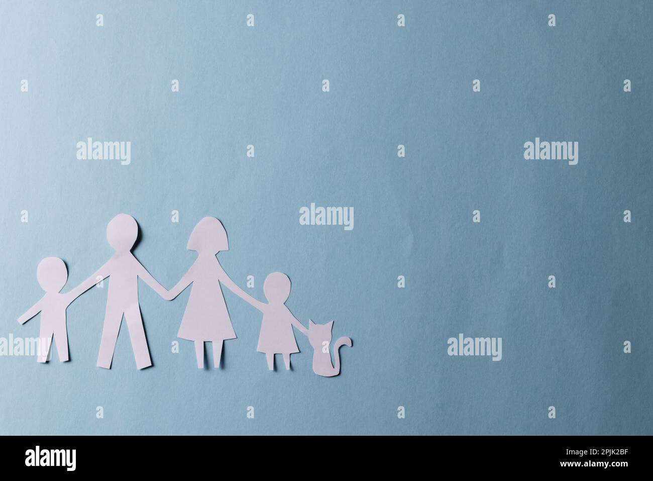 Whitepaper, ausgeschnitten aus Familie mit zwei Kindern und Katze und Kopierbereich auf blauem Hintergrund Stockfoto