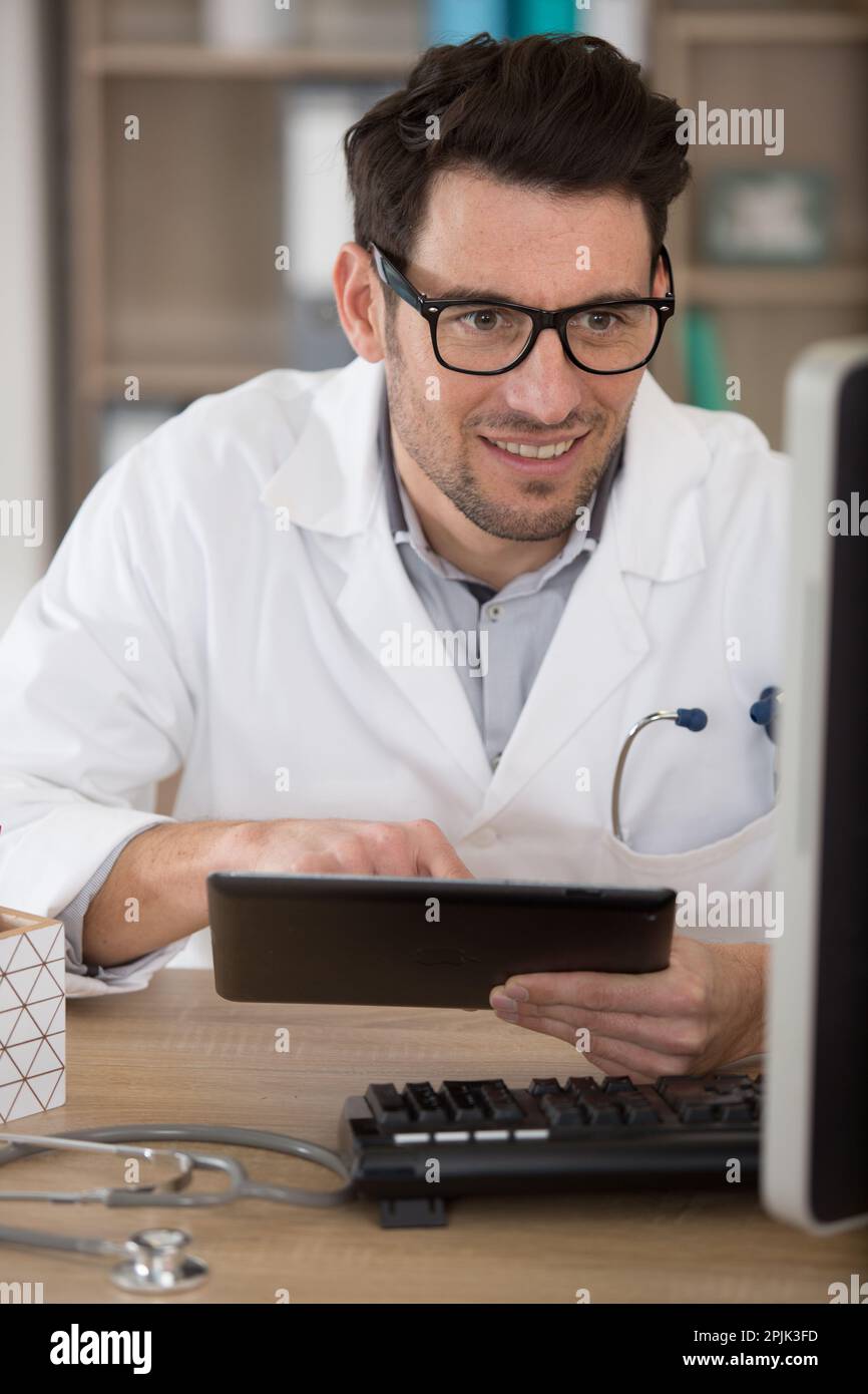 Attraktiver Arzt in der Praxis mit einem digitalen Tablet Stockfoto