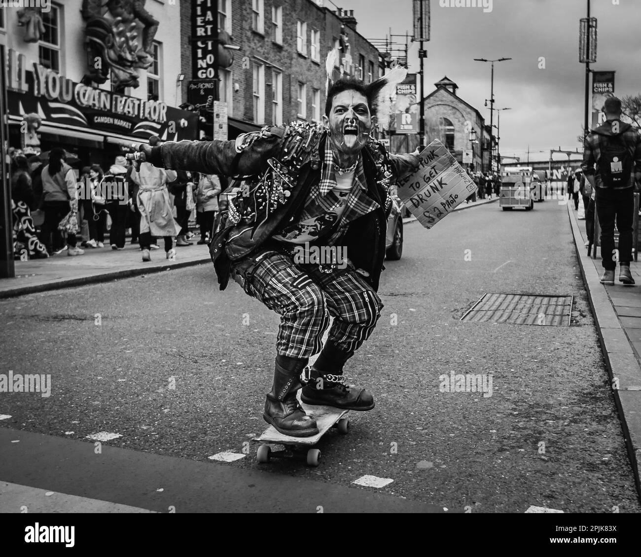 Ein Schwarzweißbild eines Punks beim Skateboarden in Londons Camden Town. Stockfoto