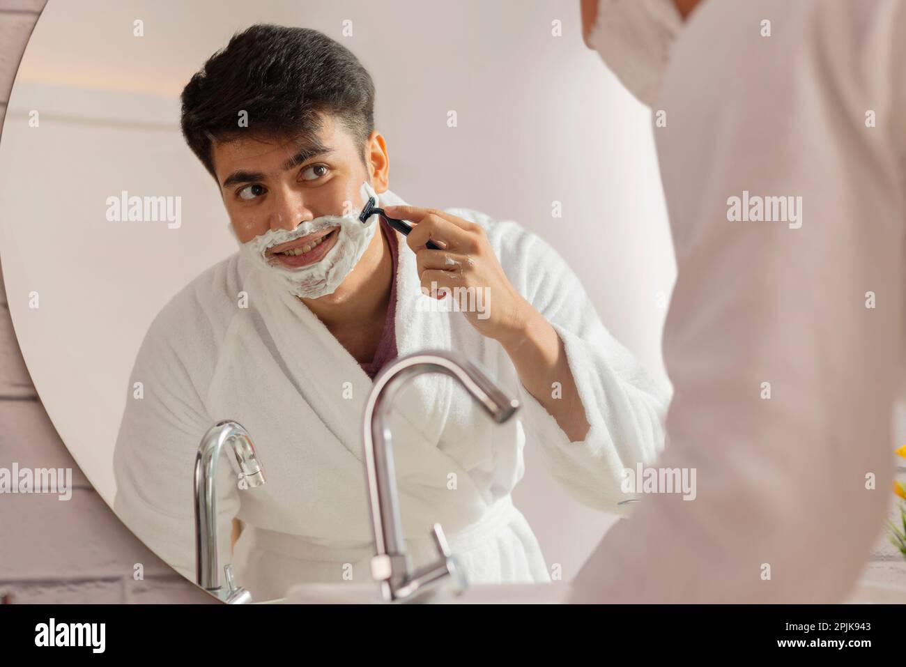 Junger Mann rasieren vor Badezimmerspiegel Stockfoto