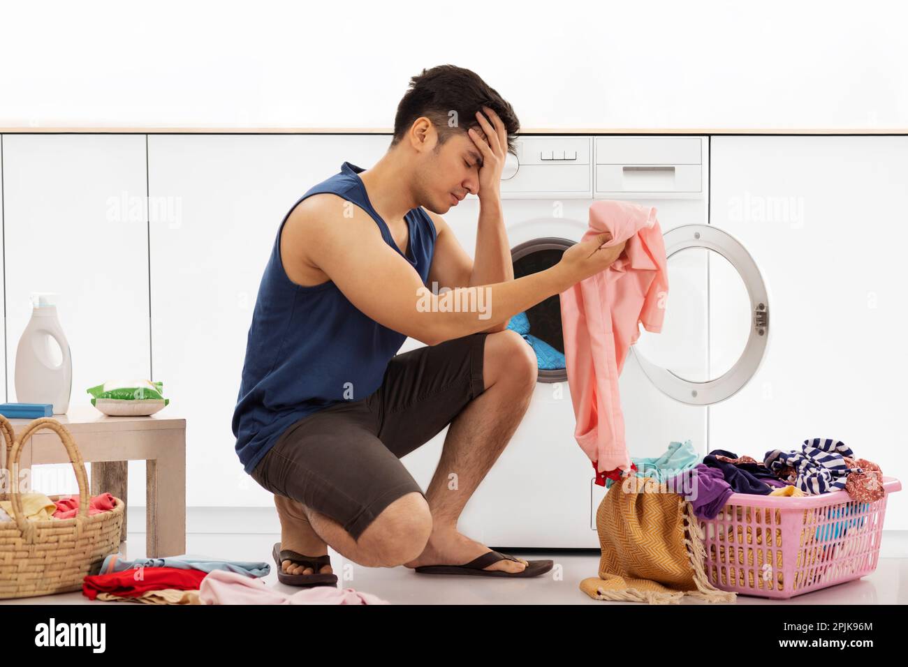 Porträt eines müden jungen Mannes, der Wäsche wäscht Stockfoto