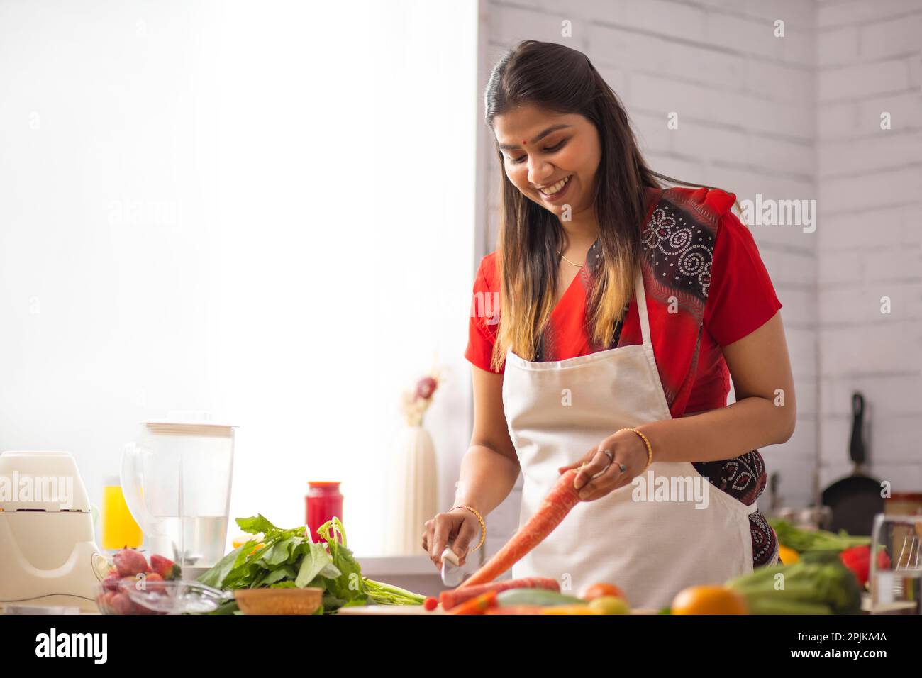 Lächelnde Frau Hacken Gemüse in der Küche Stockfoto