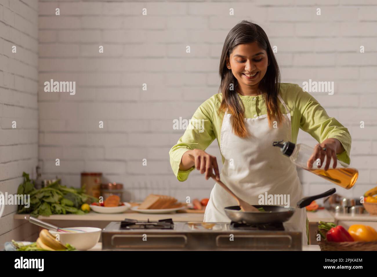 Porträt einer fröhlichen Frau, die in der Küche kocht Stockfoto