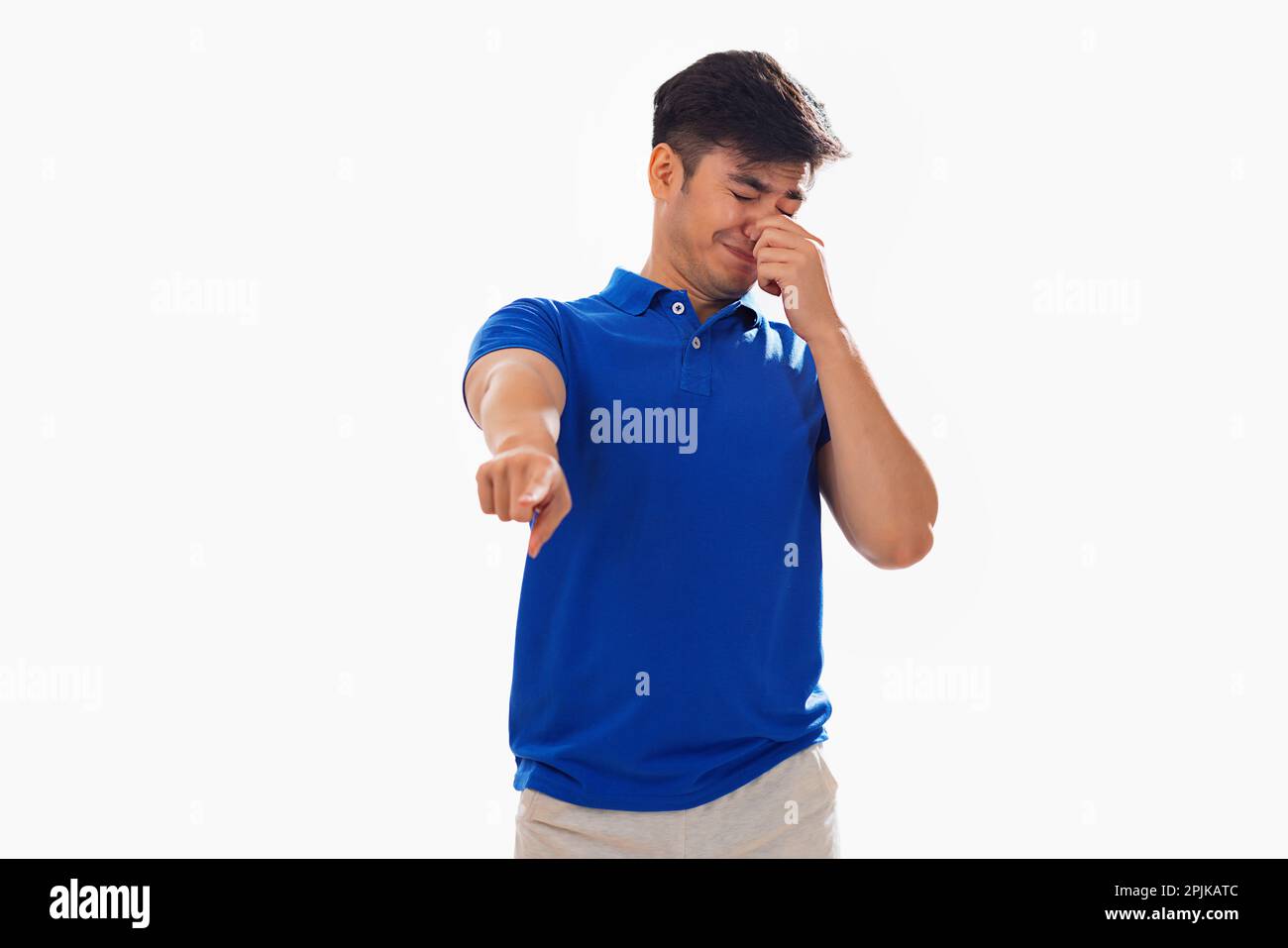 Ein junger Mann bedeckt seine Nase aufgrund eines schlechten Geruchs vor weißem Hintergrund Stockfoto