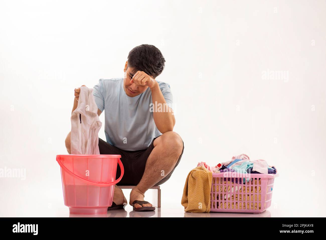 Porträt eines jungen Mannes, der seine Wäsche von Hand wäscht Stockfoto