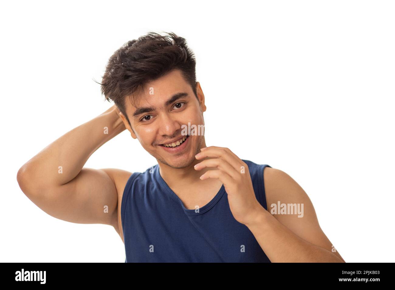 Porträt eines jungen Mannes, der seine Haare vor weißem Hintergrund fixiert Stockfoto