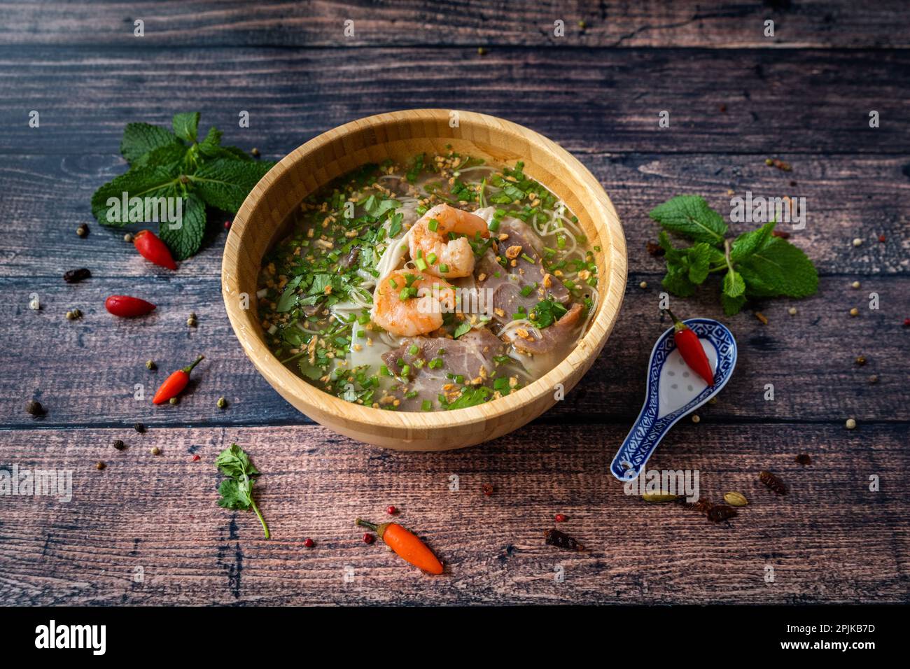 Vietnamesische Spezialität : Ravioli-Suppe in einer Schüssel und auf einem Holztisch Stockfoto