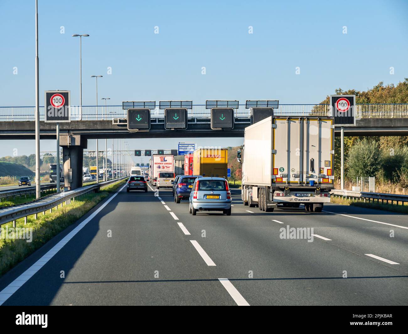 Verkehr, Geschwindigkeitsbegrenzungsschilder und Verwendung von Fahrspurmatrix-Schildern mit grünen Pfeilen auf der Autobahn A1, Niederlande Stockfoto