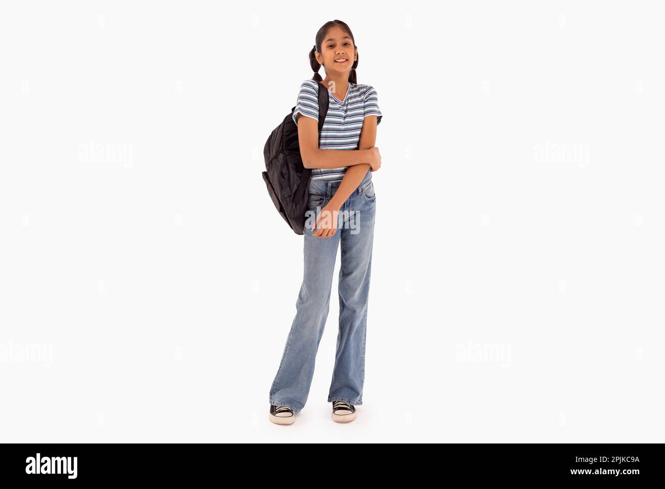 Ein Mädchen mit Rucksack steht vor weißem Hintergrund Stockfoto