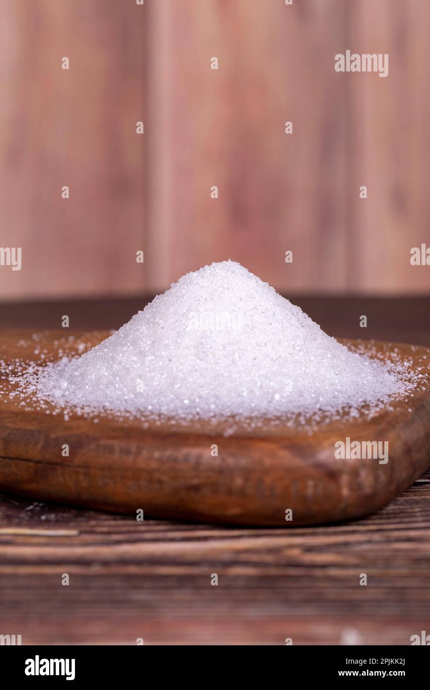 Granulatzucker. Weißer raffinierter Zucker auf Holzhintergrund. Stockfoto