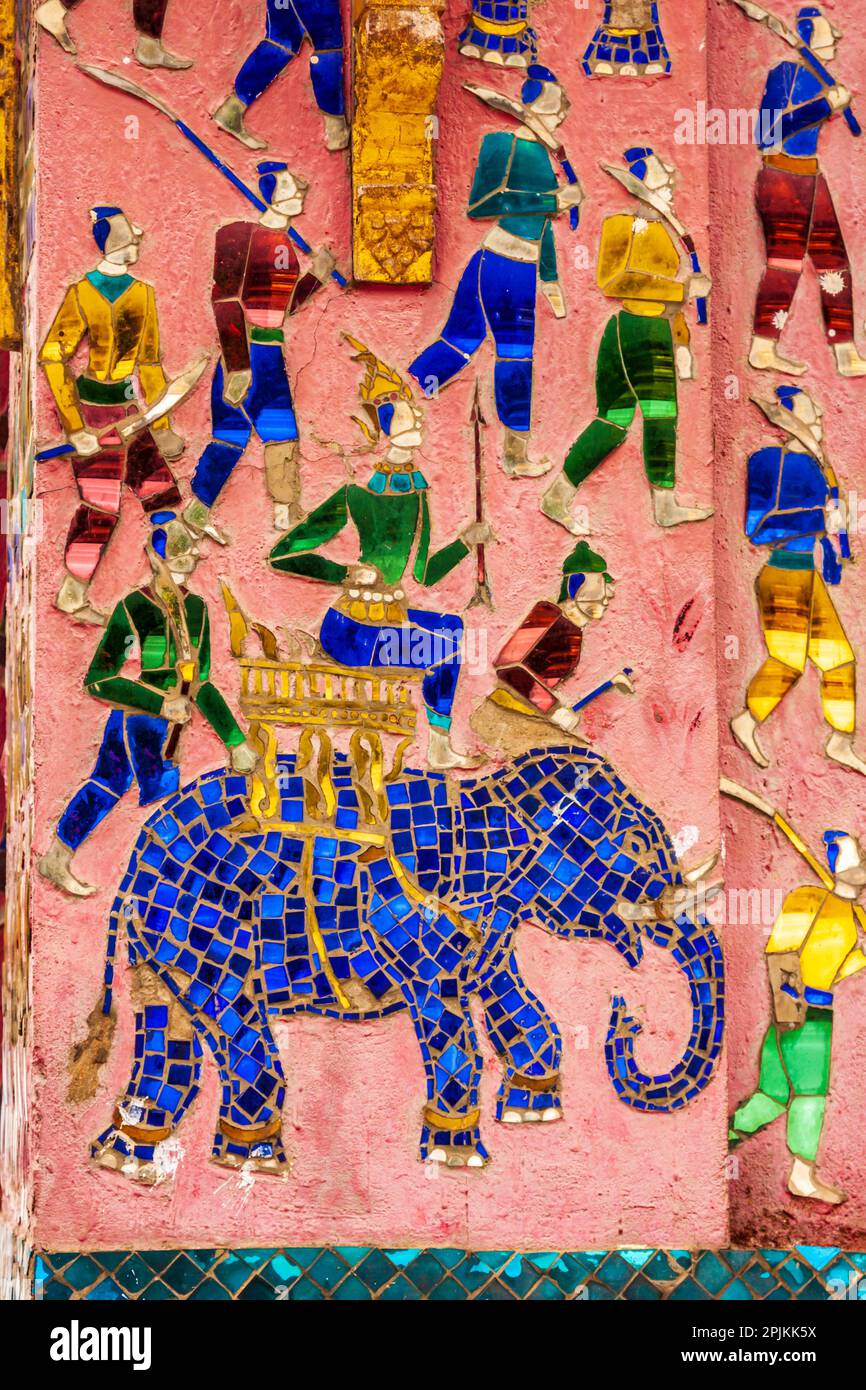 Laos, Luang Prabang. Mosaikgemälde, die einen Mann darstellen, der auf einem Elefanten reitet und sich auf die Jagd oder die Schlacht vorbereitet. Stockfoto