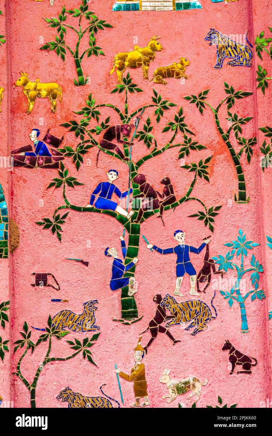 Laos, Luang Prabang. Mosaikgemälde, die Menschen und Tiere darstellen. Stockfoto