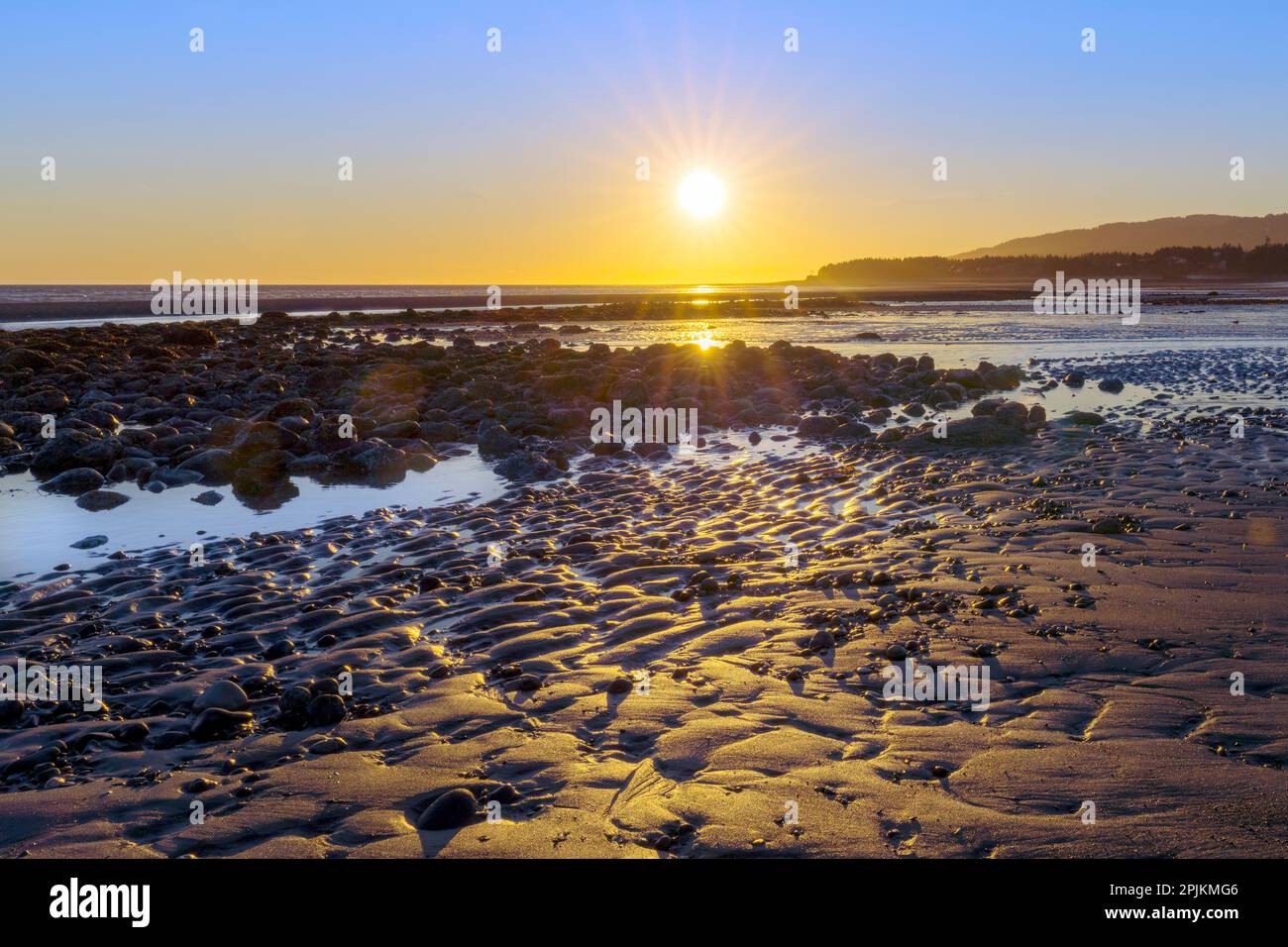 Alaska, Homer Spit. Eine Sonnenuntergangslandschaft über Gezeitentümpeln. Stockfoto