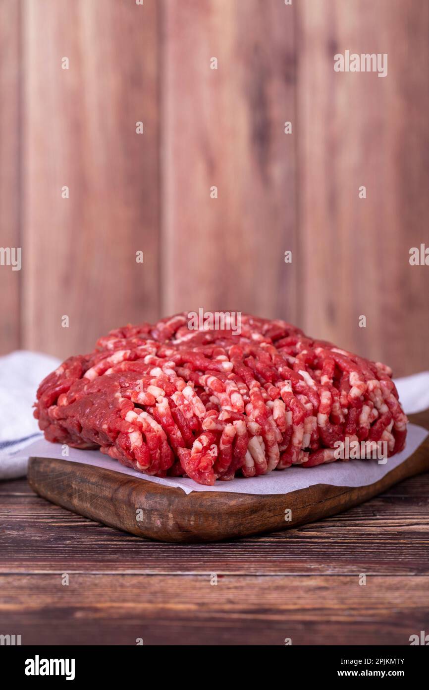 Hackfleisch auf Holzhintergrund. Rohes Hackfleisch von Kühen oder Hackfleisch Stockfoto
