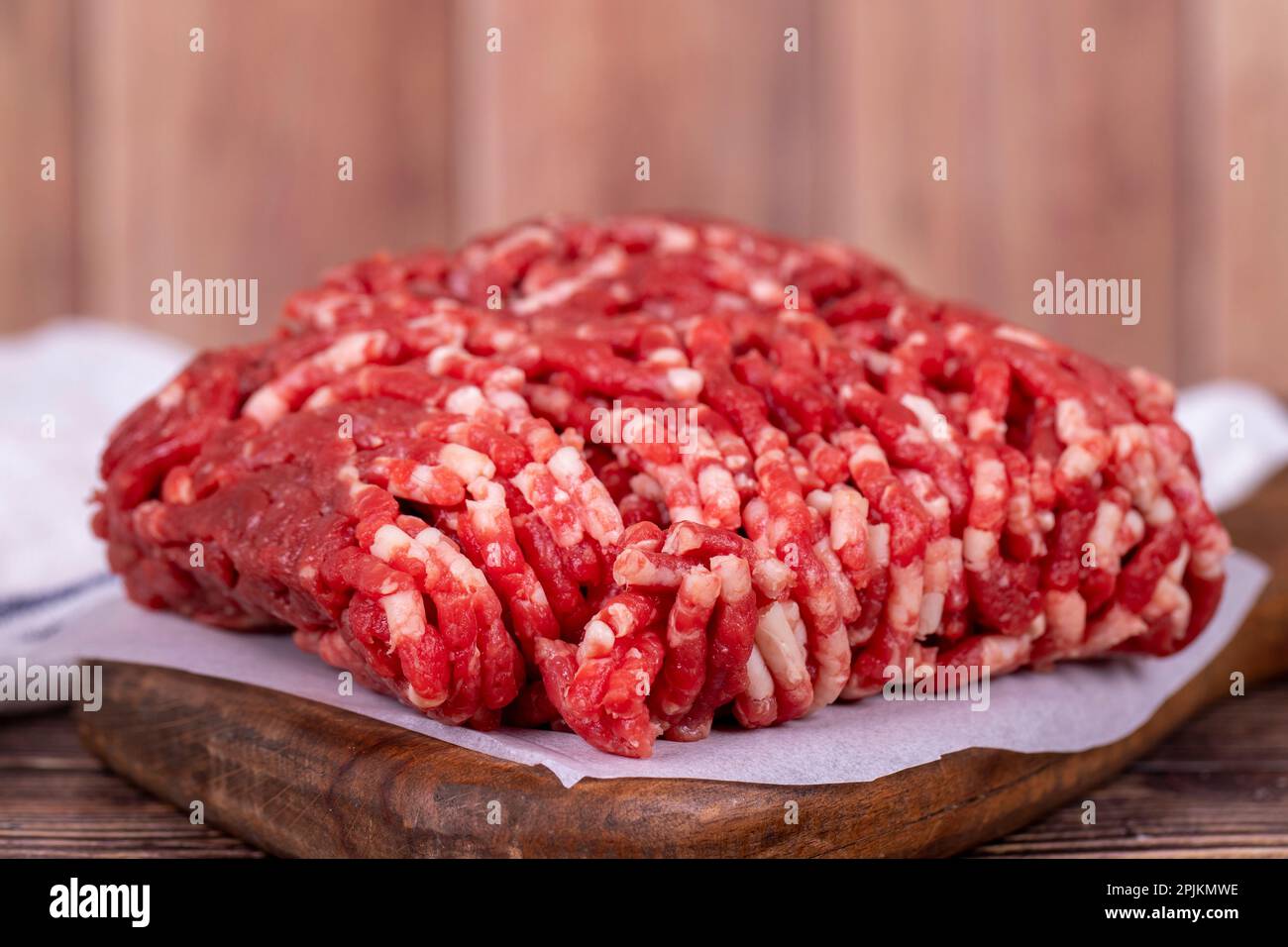 Hackfleisch auf Holzhintergrund. Rohes Hackfleisch von Kühen oder Hackfleisch. Schließen Stockfoto