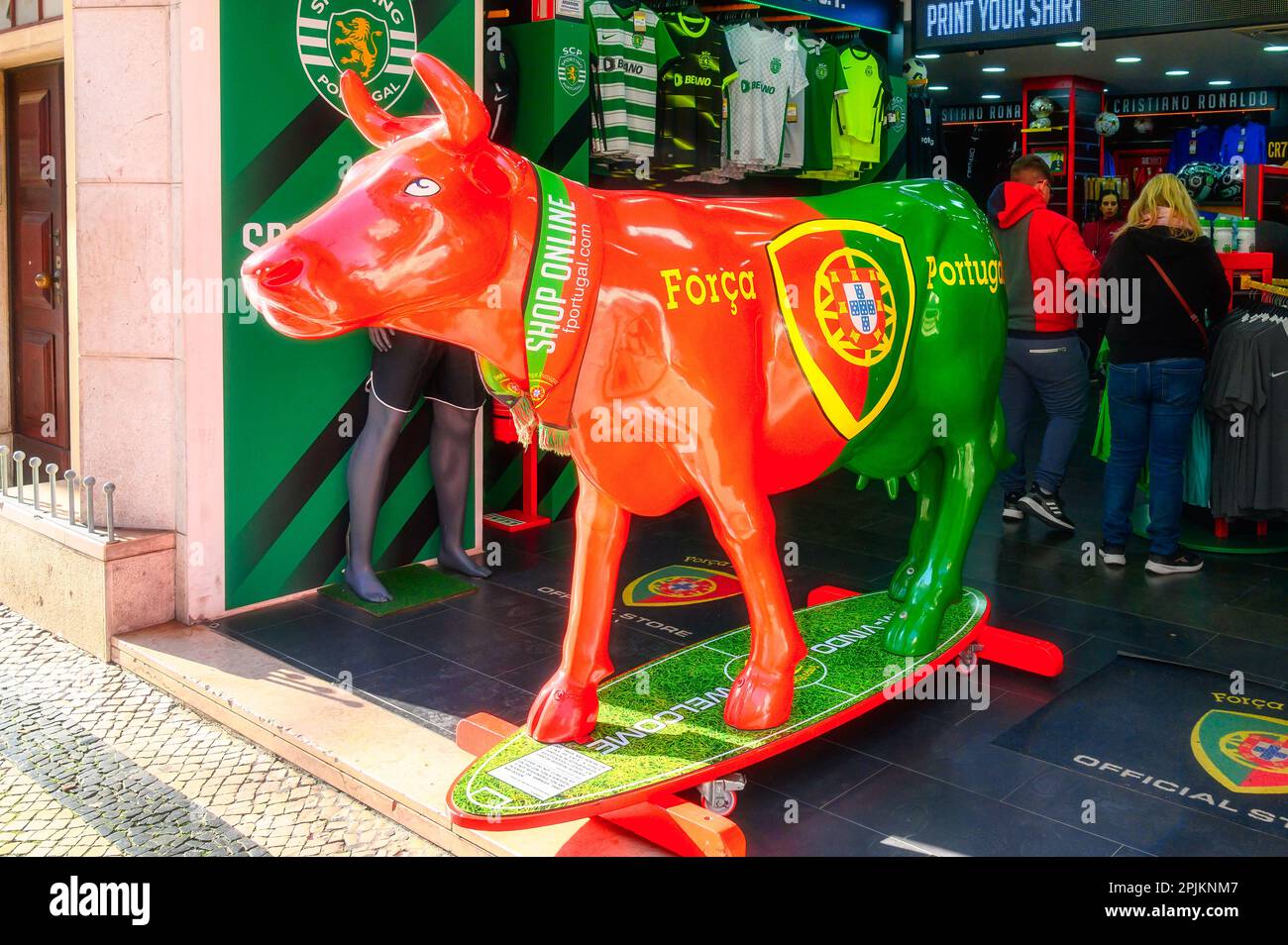 Lissabon, Portugal - 4. Januar 2023: Lebendige Kuhstatue in brasilianischen Farben vor einem Fußballgeschäft. Stockfoto